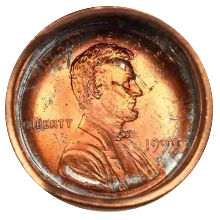Die cap and brockage error coin showing incuse mirror image impression